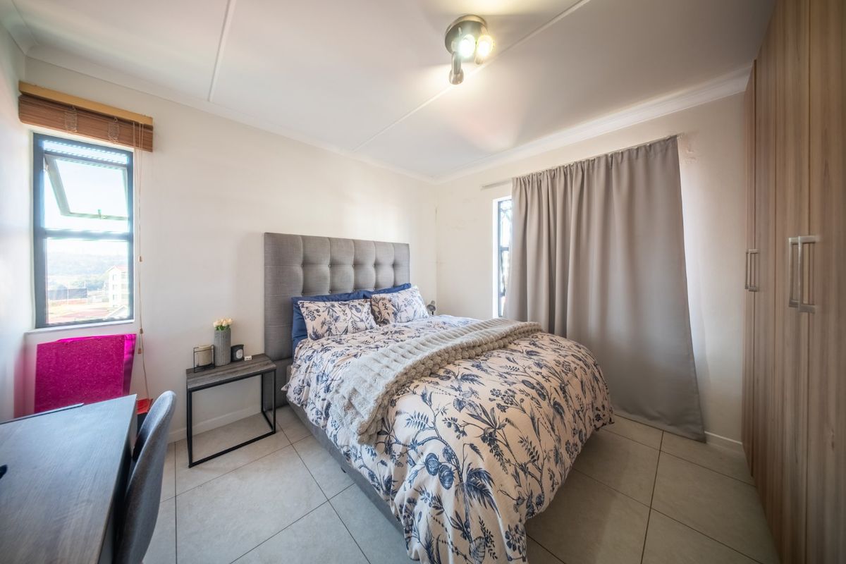 A well-maintained bedroom featuring tiled flooring, built-in cupboards, and natural light from the top-hung window.