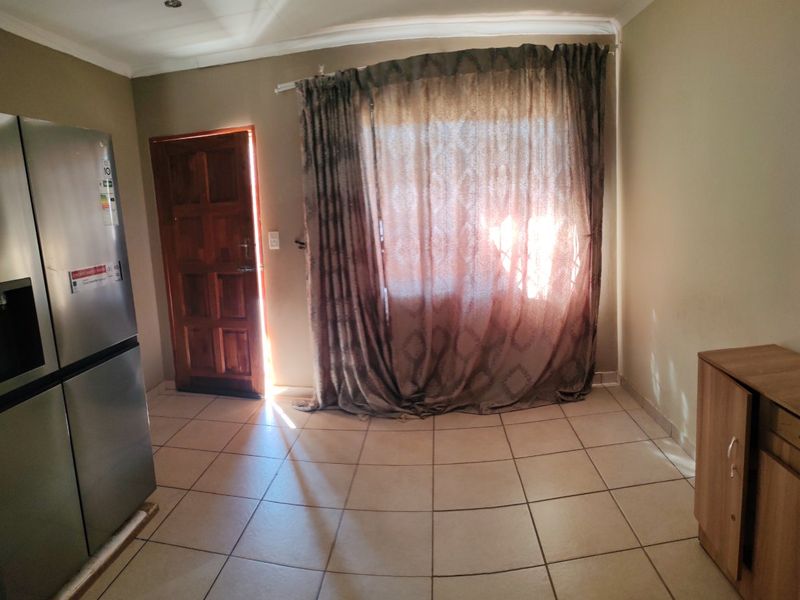 A functional kitchen area featuring tiled flooring, recessed lighting, and direct access to an exterior door.