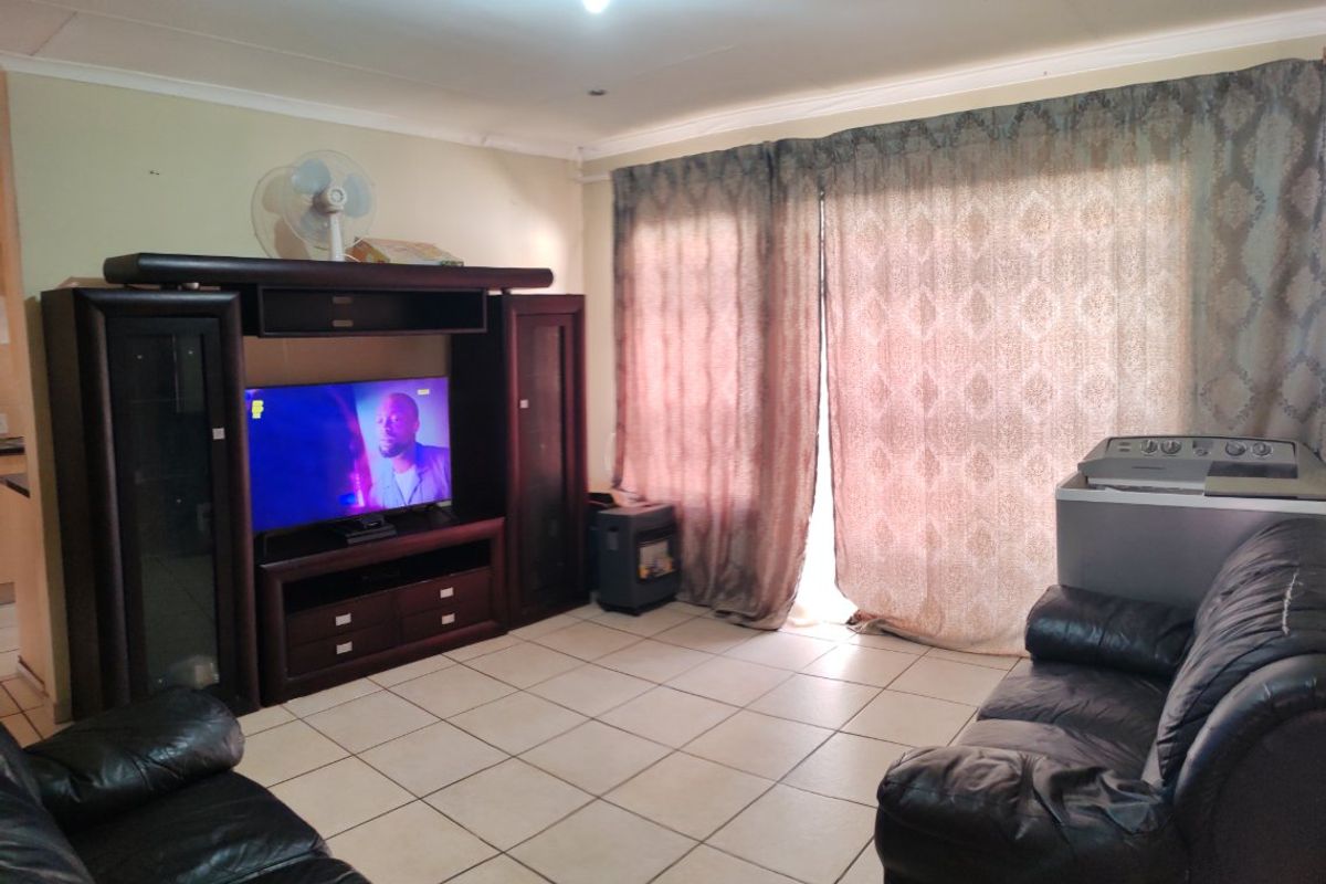 A living room featuring ceramic tiled flooring and coved ceilings, providing a functional space with potential for cosmetic updates to enhance the interior aesthetic.