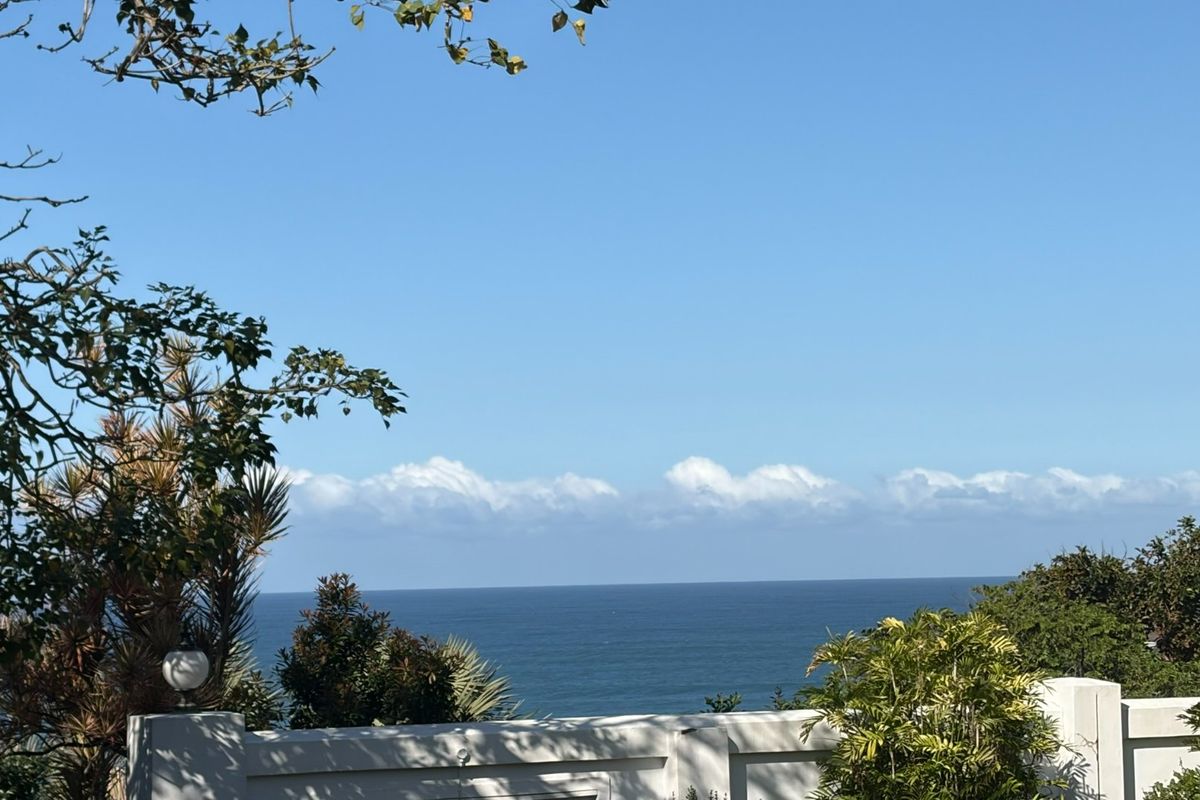 A scenic ocean view captured from the property, featuring a clear horizon and a well-maintained boundary wall in the foreground.