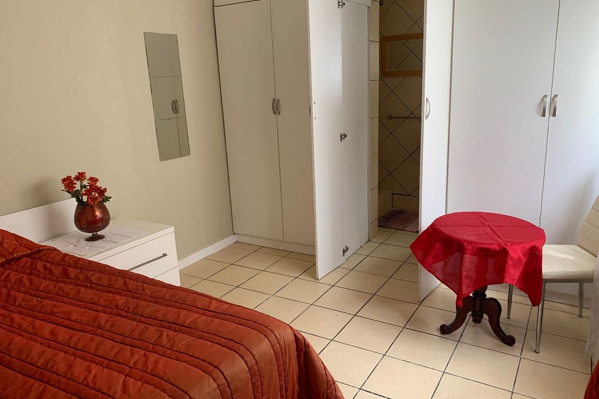 Bedroom featuring tiled flooring, built-in cupboards, and direct access to an en-suite bathroom.