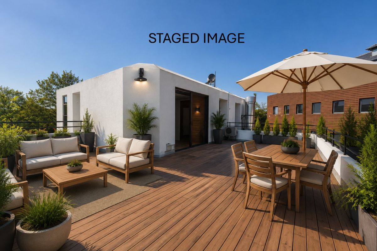 Spacious rooftop terrace featuring timber decking, modern wall lighting, and sliding door access, providing an ideal outdoor entertainment area.