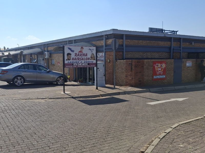 Exterior view of a commercial retail unit featuring face brick construction and dedicated paved parking space.