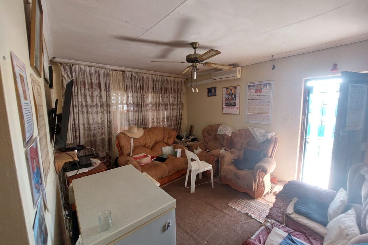 A living room featuring a ceiling fan, split-system air conditioning, and direct access to an exterior security gate.
