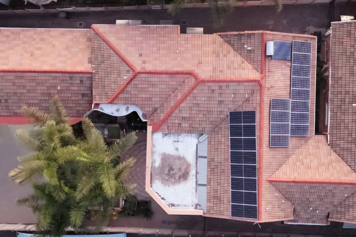 Aerial view of the property showing the tiled roof structure, integrated solar panels, and solar geyser installation.