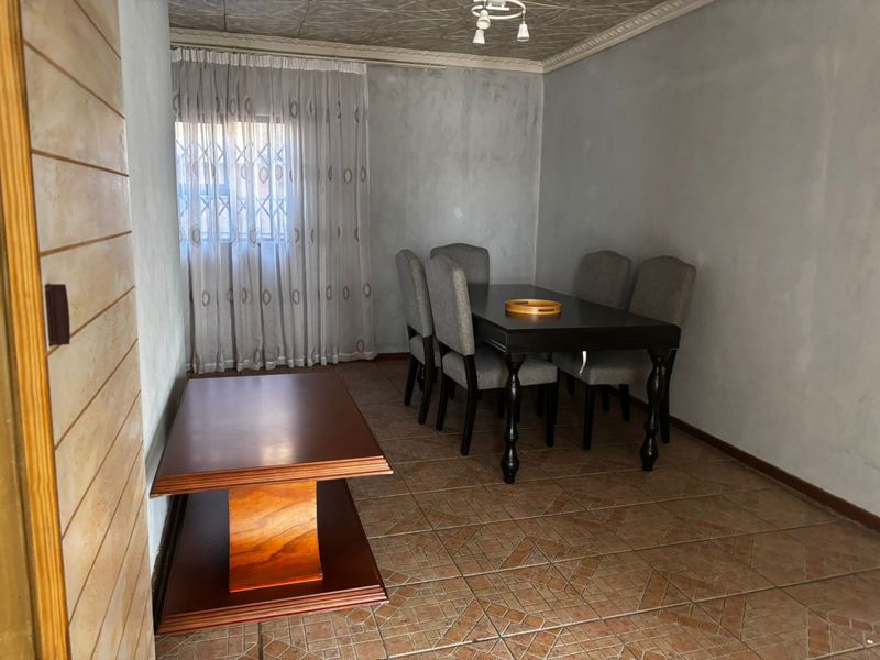 A dining room featuring tiled flooring and decorative ceiling tiles, providing a functional space for meals.