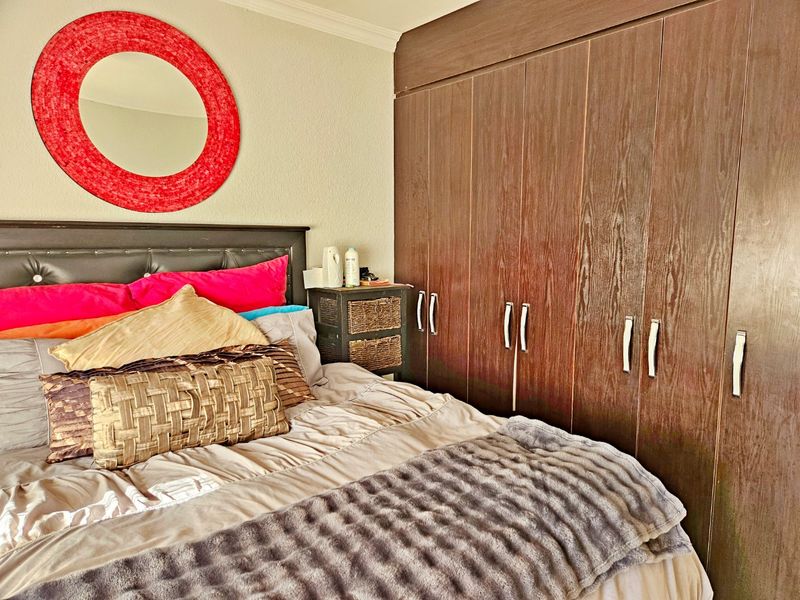 A bedroom featuring dark wood built-in cupboards and crown molding, providing ample storage space.