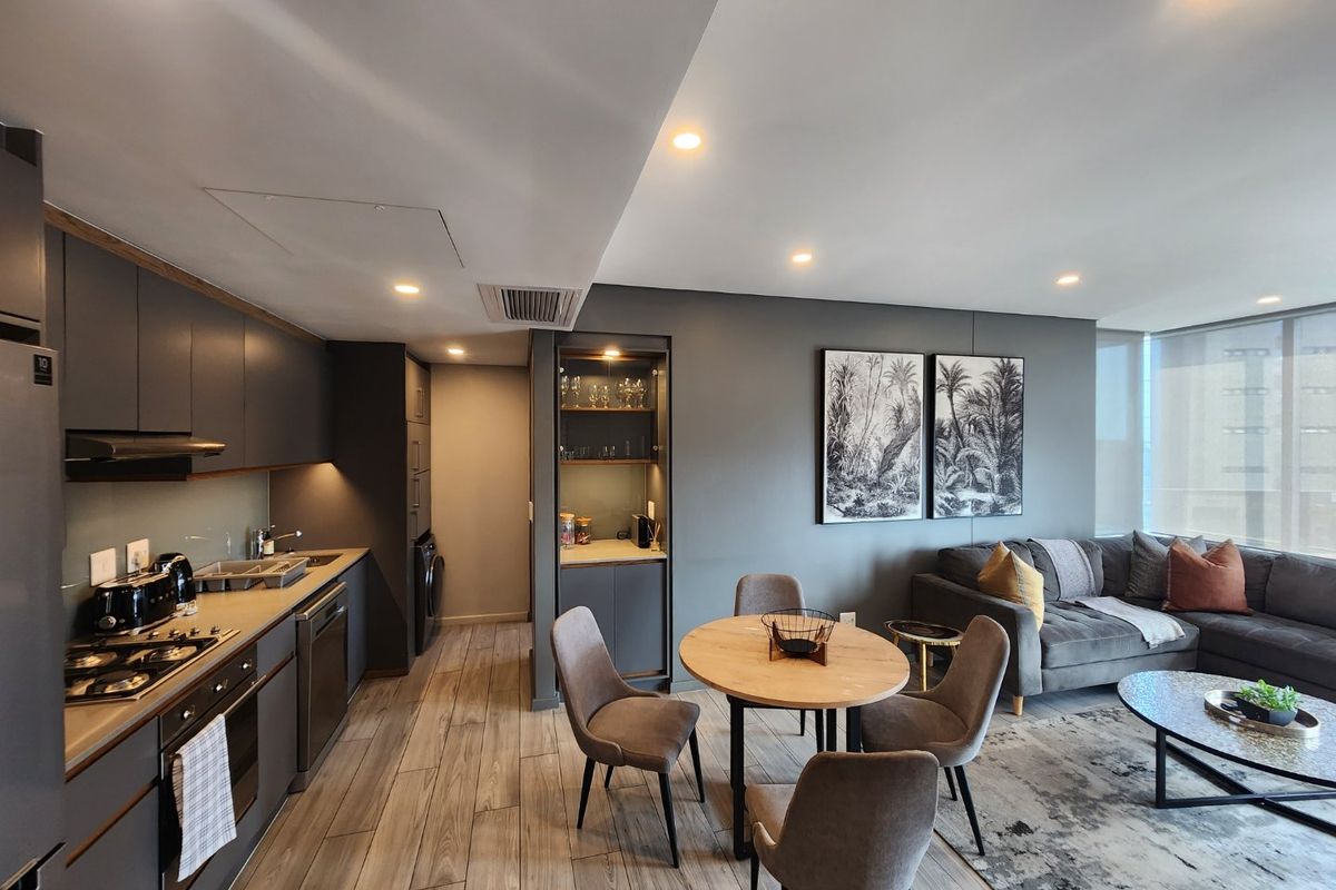 Modern open-plan apartment featuring a sleek kitchen with integrated appliances, a dedicated dining area, and a comfortable living space with contemporary finishes.