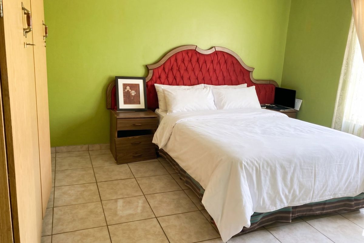 A bedroom featuring tiled flooring and a built-in wardrobe, providing a functional space with neutral base finishes.