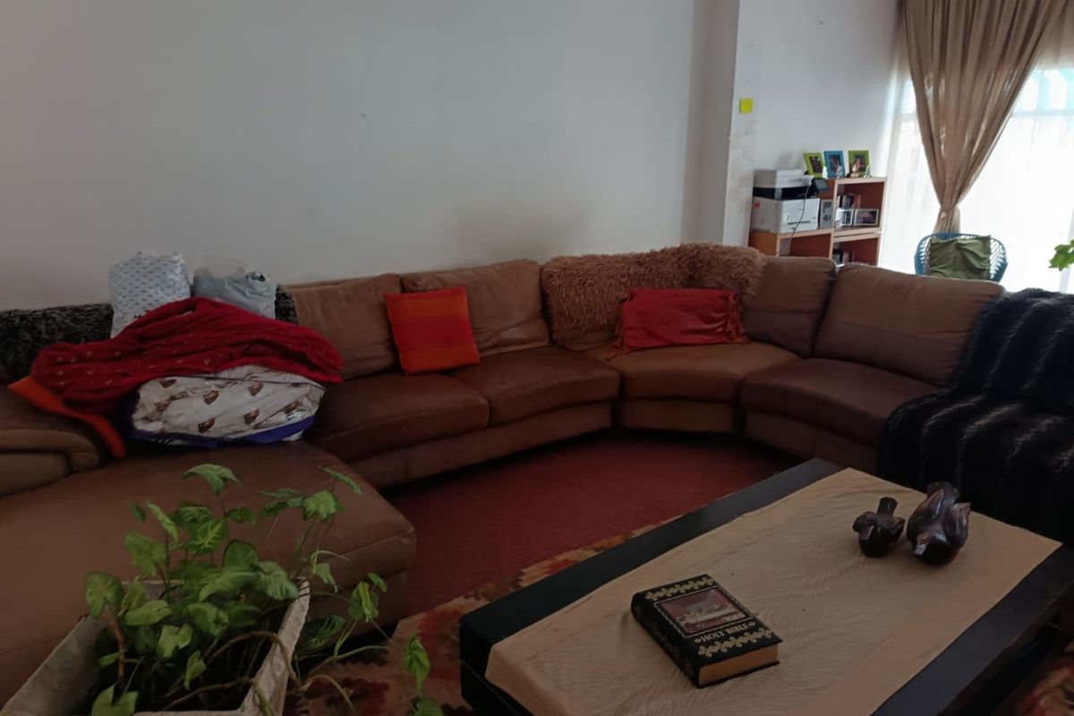 A living room space featuring neutral wall finishes and carpeted flooring, offering a blank canvas for potential interior updates and modernization.