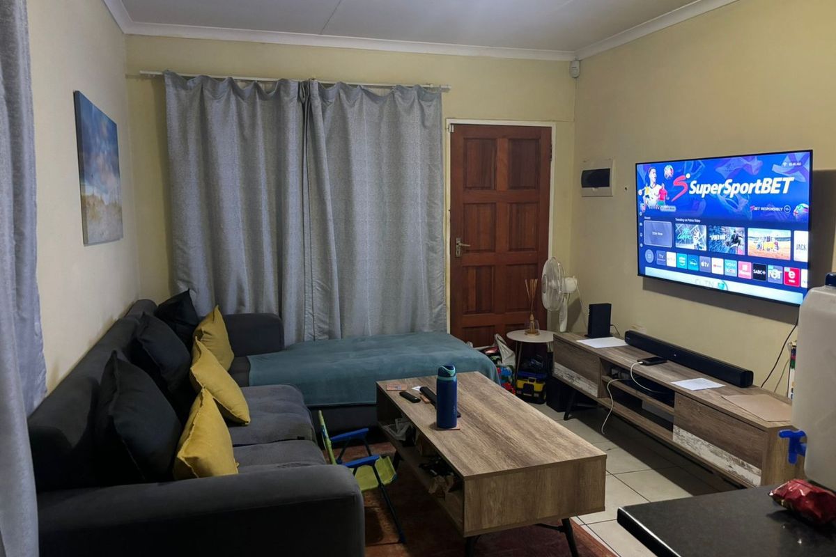 A functional living room featuring tiled flooring and coved ceiling details, providing a comfortable space for relaxation and entertainment.