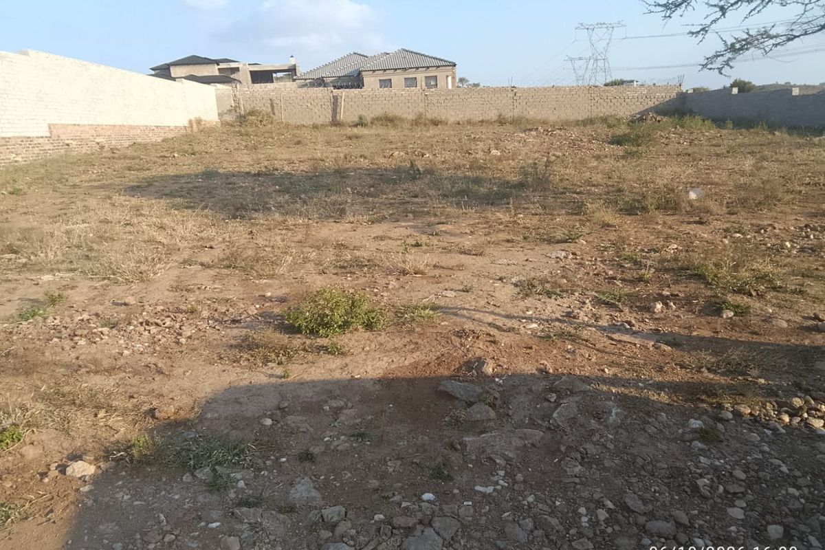 A vacant residential plot of land enclosed by perimeter walls, offering a clear space for future development.