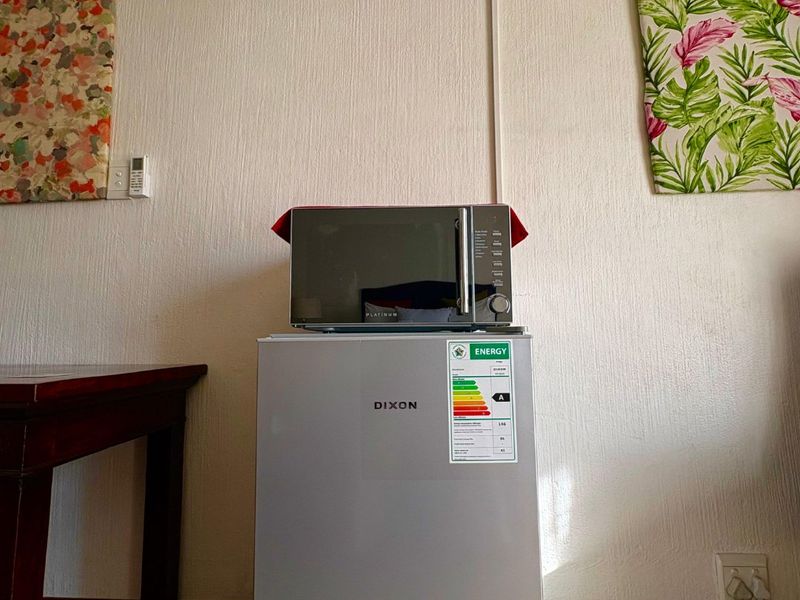 A living area featuring a wall-mounted air conditioning unit and standard electrical infrastructure.
