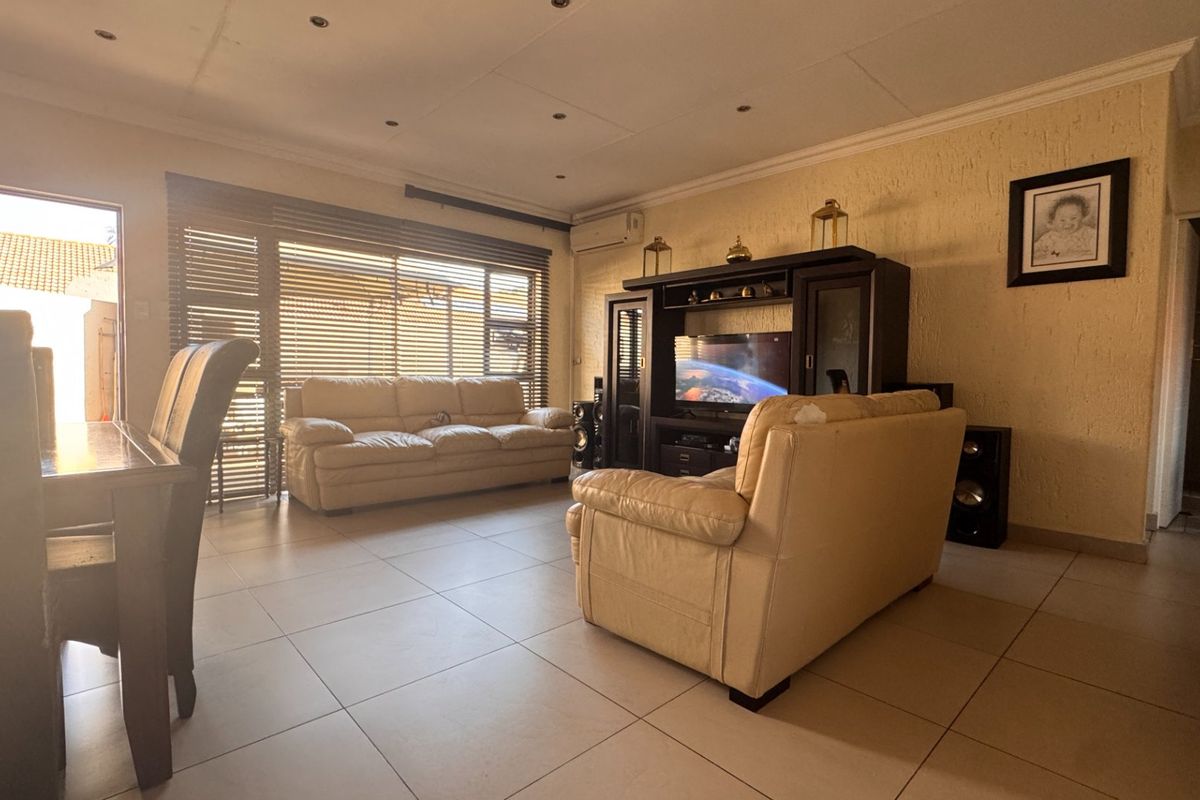 Spacious living area featuring tiled flooring, recessed lighting, and an air conditioning unit, with direct access to an outdoor space through a sliding door.