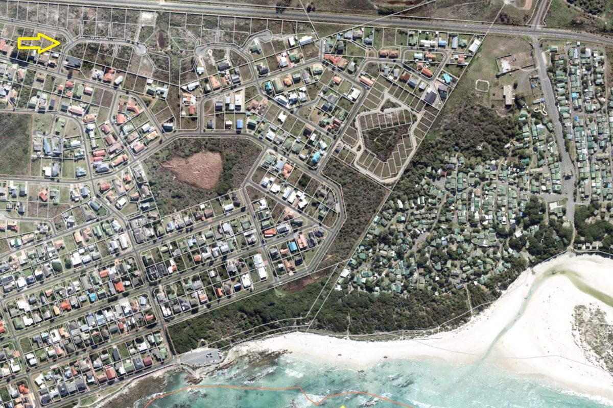 An aerial view of a coastal residential estate showing the layout of subdivided plots, street infrastructure, and proximity to the beach.