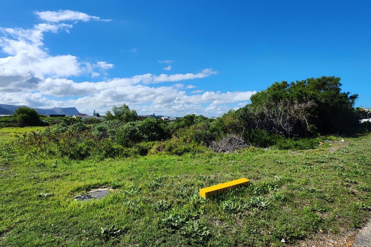 A view of a vacant residential plot featuring natural vegetation and open space, ready for development.