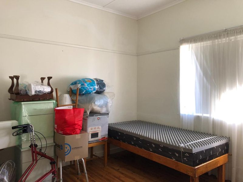 A bedroom featuring original timber flooring and a classic picture rail, offering a blank canvas for potential renovation or restyling.