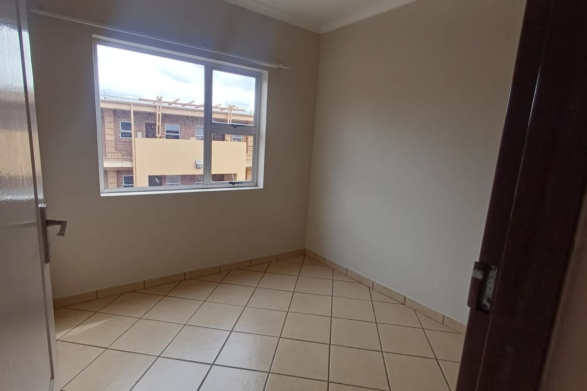 An empty bedroom featuring neutral wall paint and tiled flooring, providing a blank canvas for personalization.