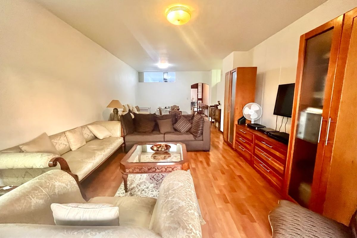 Spacious living room featuring hardwood flooring and neutral wall finishes, offering a comfortable and functional layout for relaxation and entertainment.