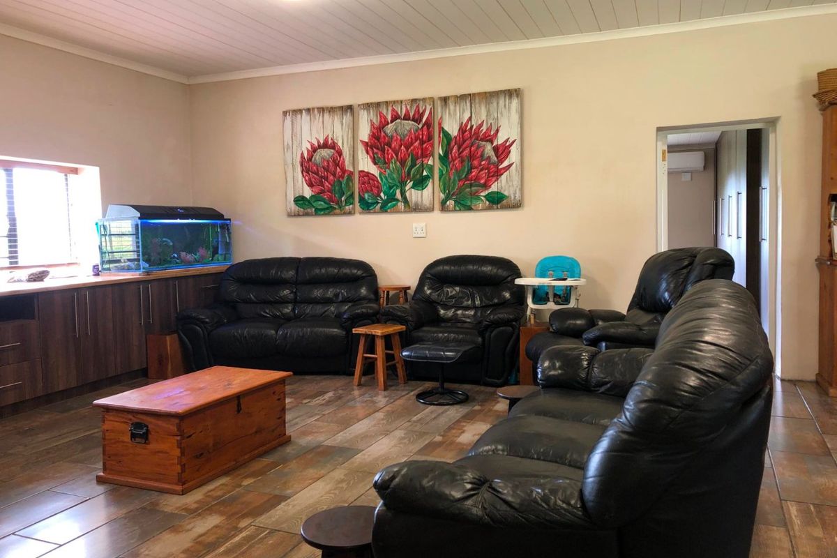Spacious living room featuring wood-look tiled flooring, built-in cabinetry, and a tongue and groove ceiling.