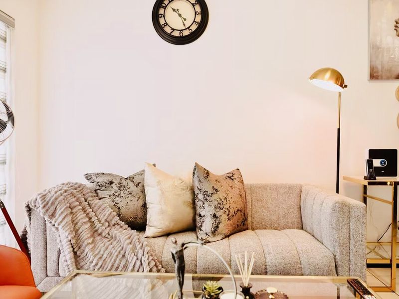 A well-lit living room area featuring modern window blinds and neutral wall finishes.