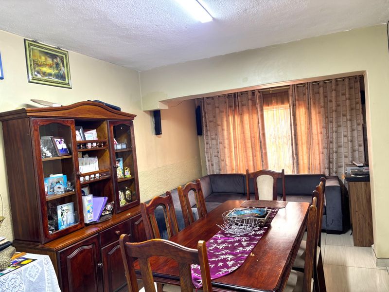 Dining room area featuring tiled flooring and a recessed curtain track, requiring cosmetic updates to the wall finishes.