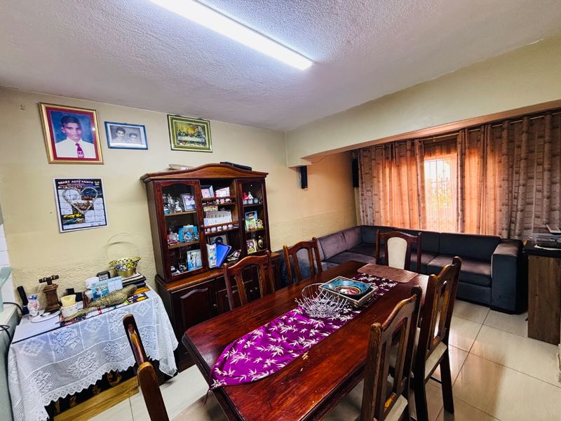 A dining room featuring tiled flooring and a central ceiling light, providing a functional space for family meals.
