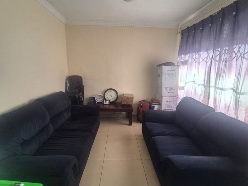 A living room featuring tiled flooring and decorative ceiling cornicing, providing a functional space for relaxation.