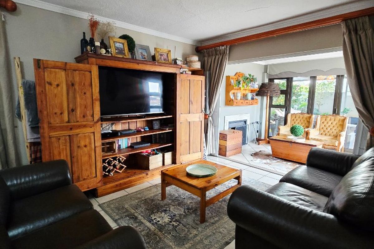 Spacious living room featuring tiled flooring, a fireplace, and large sliding glass doors that provide natural light and access to the outdoor area.
