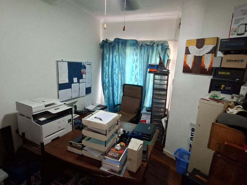 A functional home office space featuring hardwood flooring and a ceiling fan, providing a dedicated area for work or study.