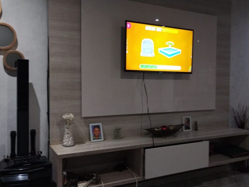 A living room featuring a built-in media console and a wall-mounted television panel with integrated shelving.