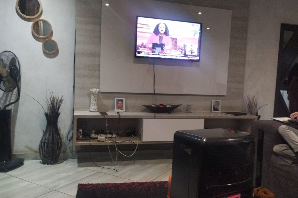 A living room featuring a built-in media console and tiled flooring, providing a functional space for entertainment.