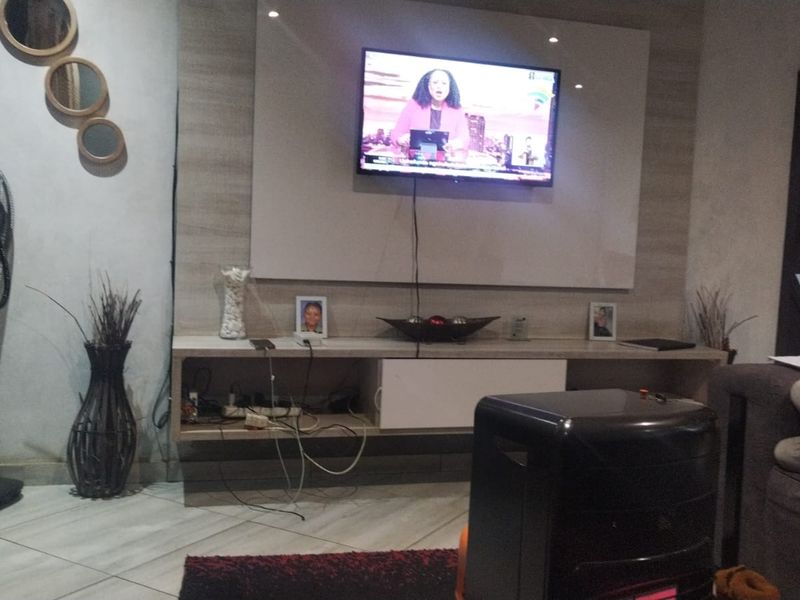 A living room featuring a built-in media console and tiled flooring, providing a functional space for entertainment.