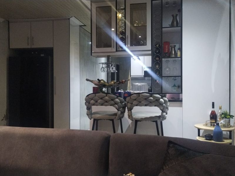 Open plan living area featuring modern built-in cabinetry with integrated glass display shelving and a dedicated wine rack.