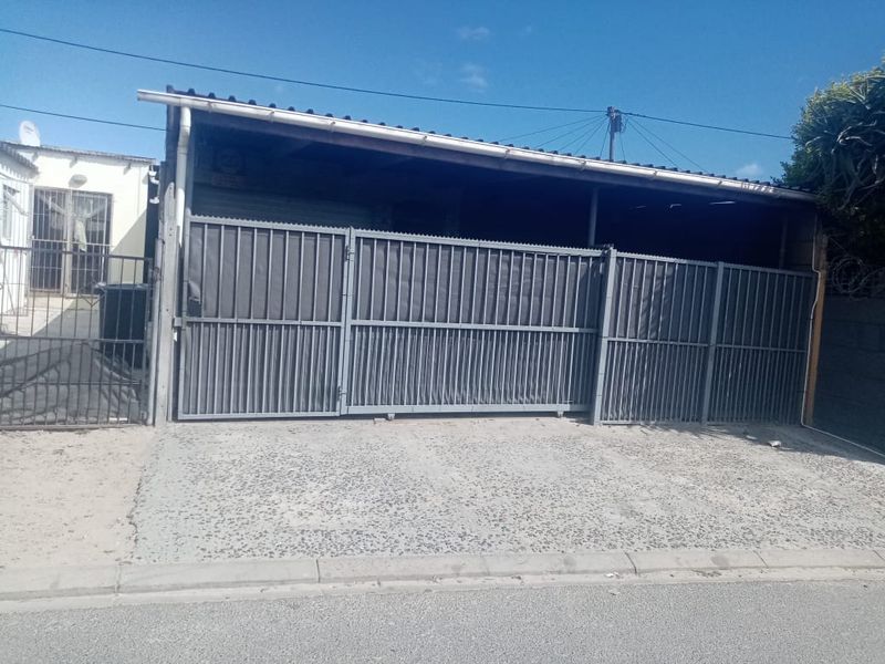 A functional garage structure featuring a metal sliding gate and a concrete driveway, providing secure off-street parking.