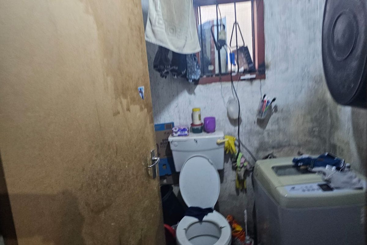 A small bathroom space requiring significant renovation and repair to the wall finishes and overall infrastructure.