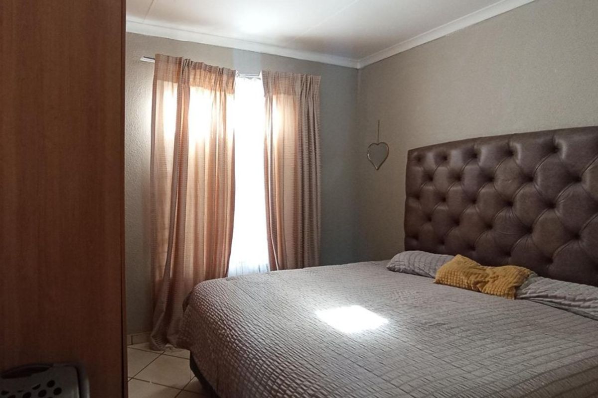 A comfortable bedroom featuring tiled flooring and coved ceiling details, providing a neutral and functional space.