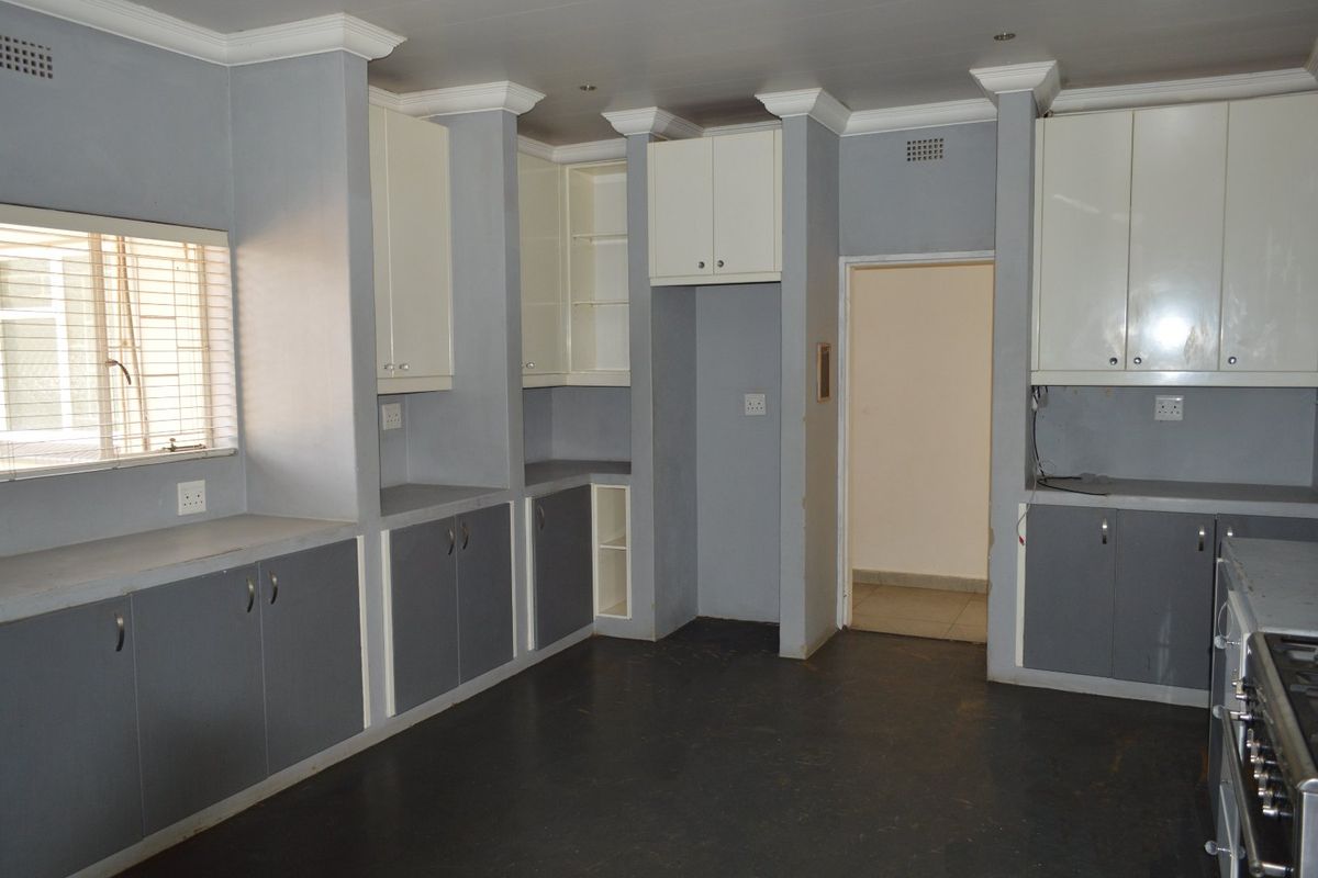 A functional kitchen featuring built-in cabinetry, crown molding, and a gas stove, offering a blank canvas for potential updates and modern finishes.