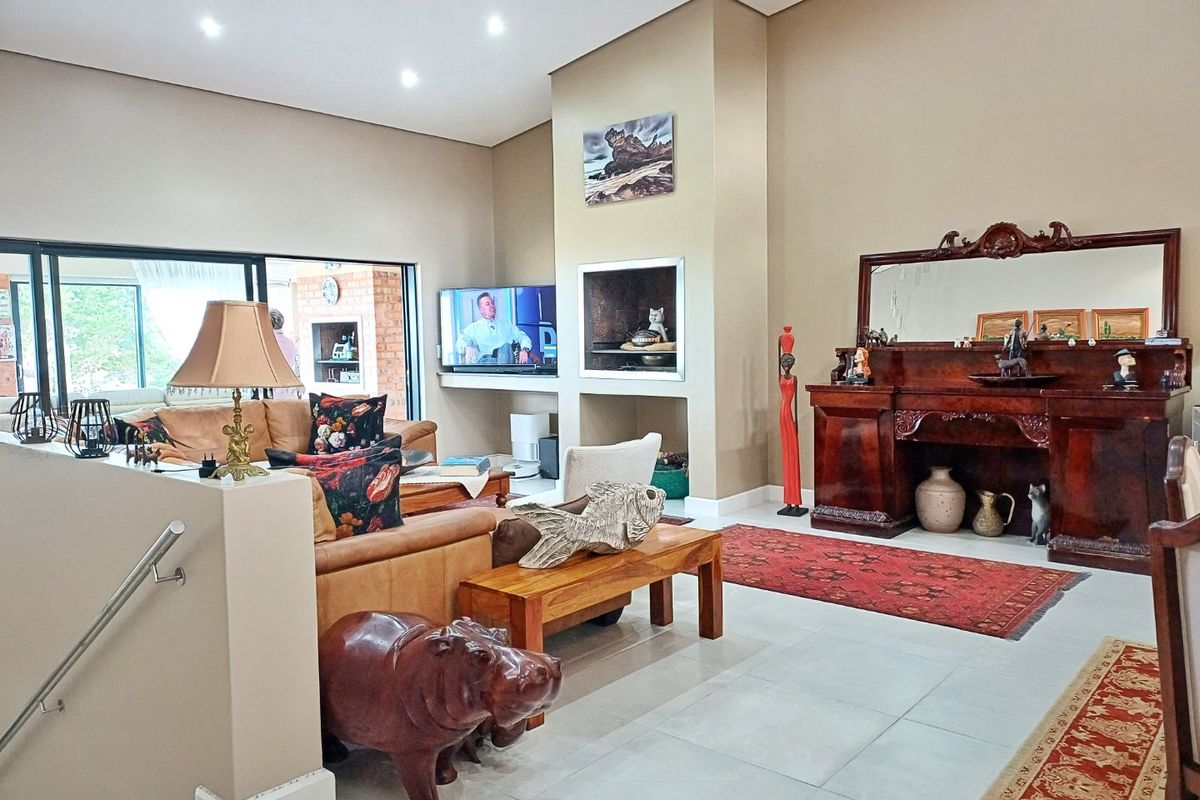 Spacious living room featuring tiled flooring, recessed lighting, and a built-in fireplace, with large sliding doors providing access to the outdoor area.