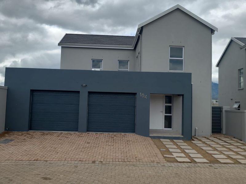 Front elevation of a modern double-storey house featuring a double garage, paved driveway, and neutral exterior finish.