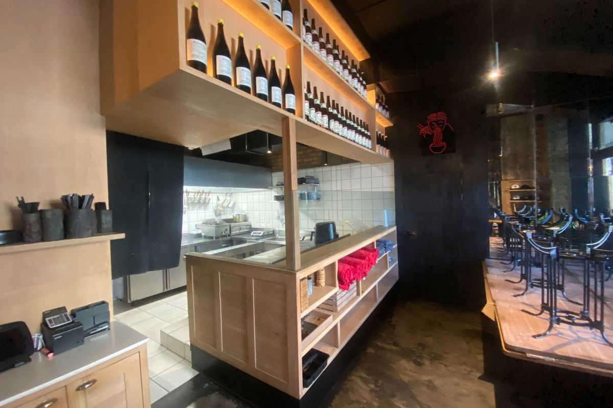 A well-maintained commercial kitchen area featuring custom timber shelving, integrated lighting, and stainless steel prep surfaces, designed for efficient food service operations.