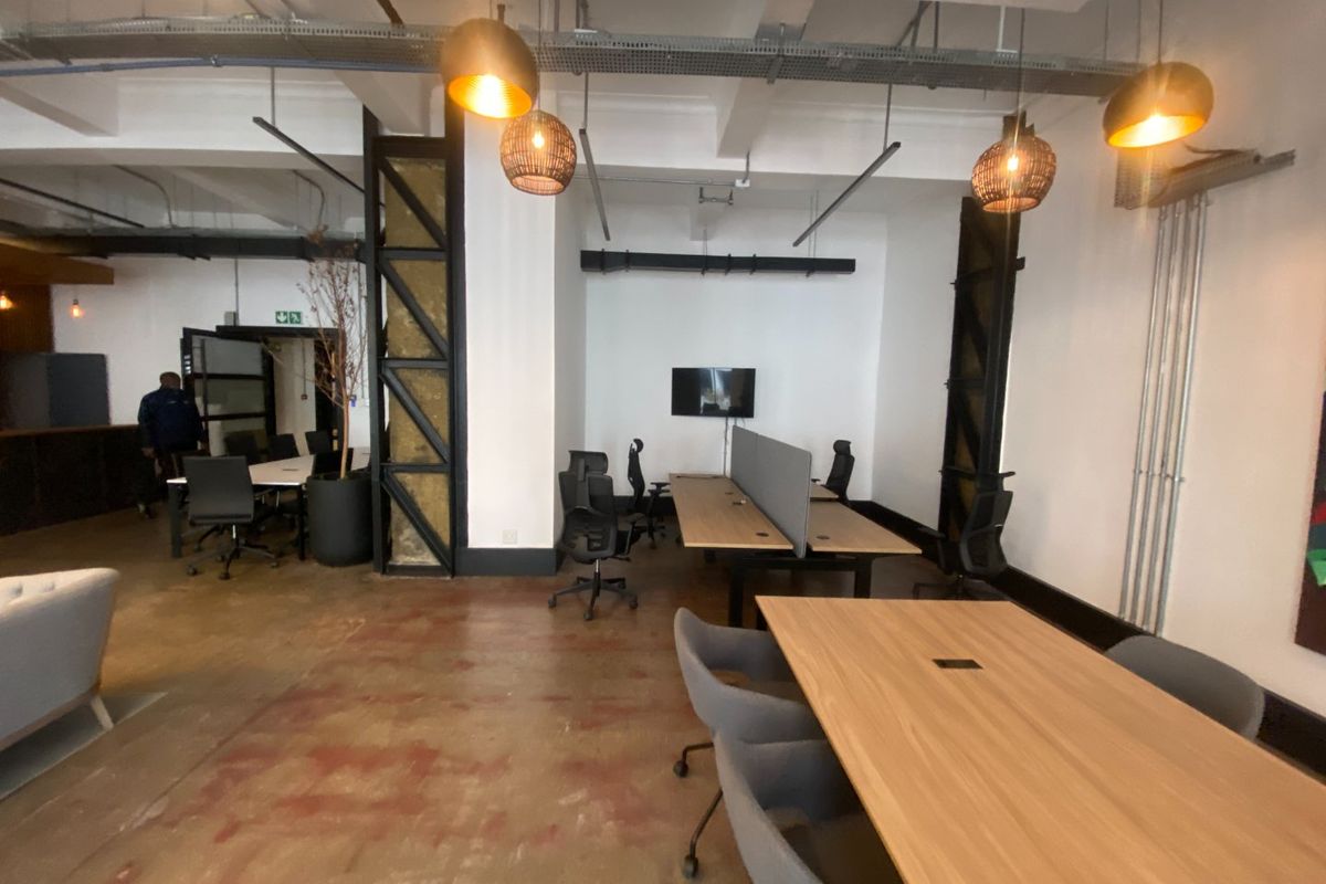 Modern industrial-style office space featuring exposed ceilings, polished concrete floors, and steel structural elements, providing a contemporary open-plan work environment.
