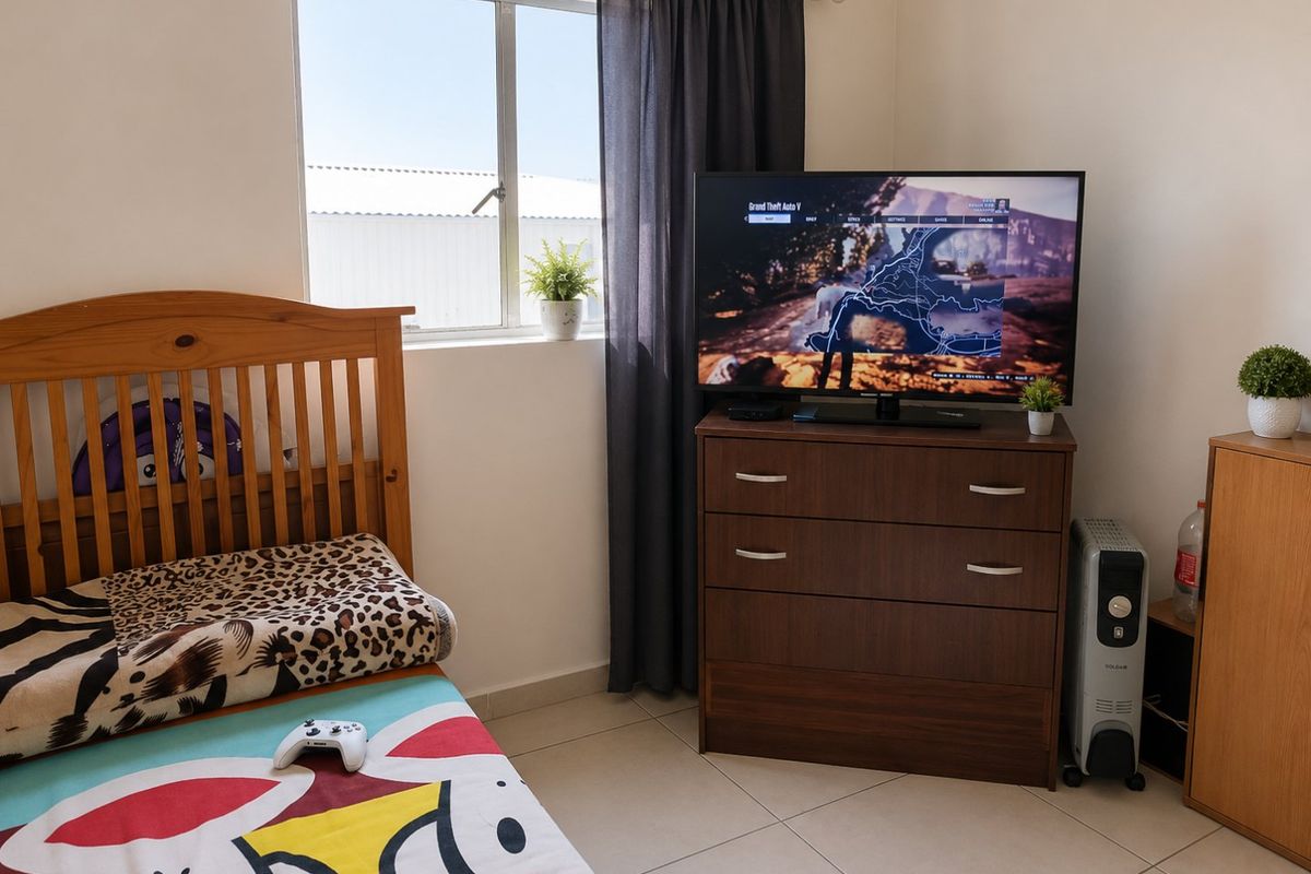 A functional bedroom featuring tiled flooring and a window with curtain rails, providing natural light and a neutral base for personalization.
