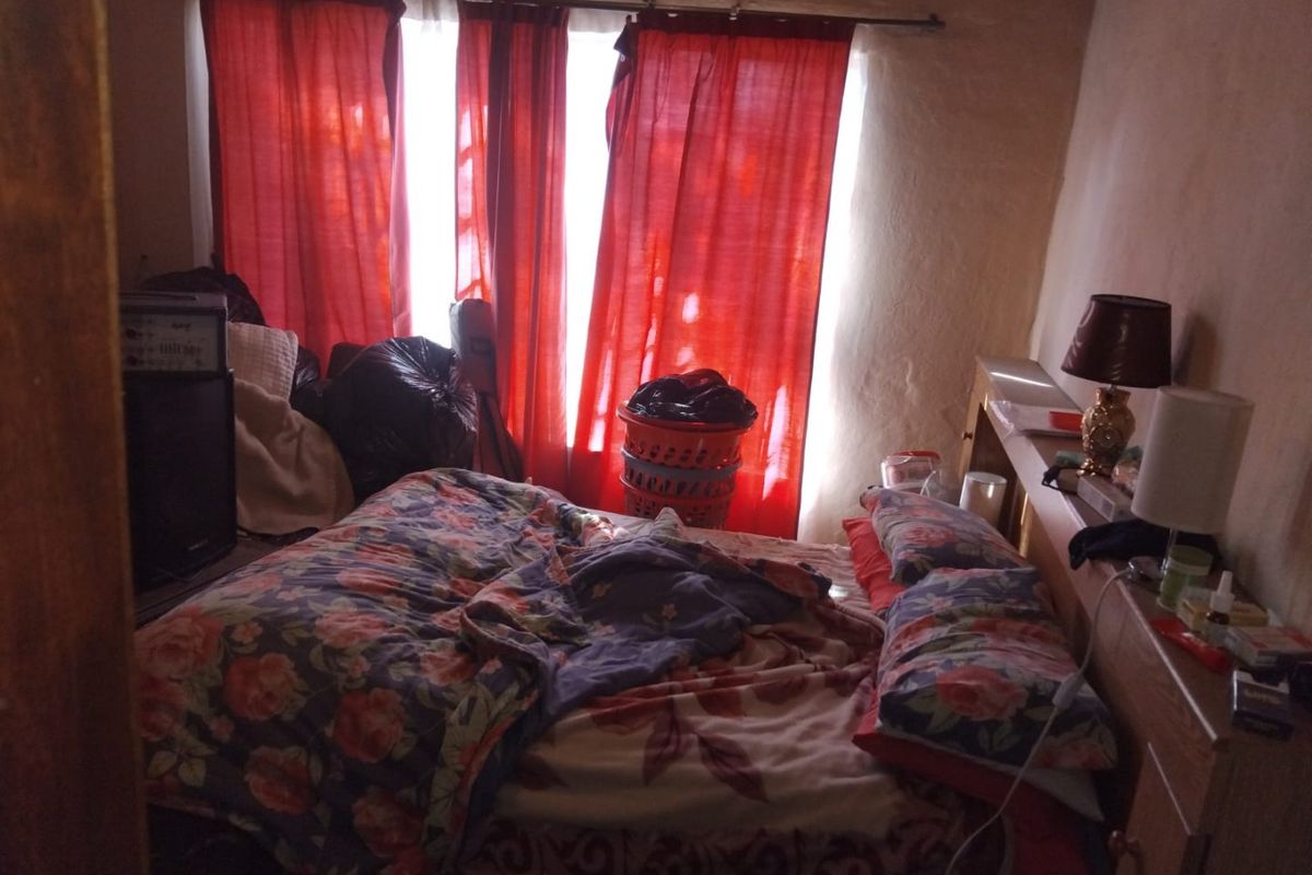 A bedroom featuring a built-in headboard and natural light from the window.