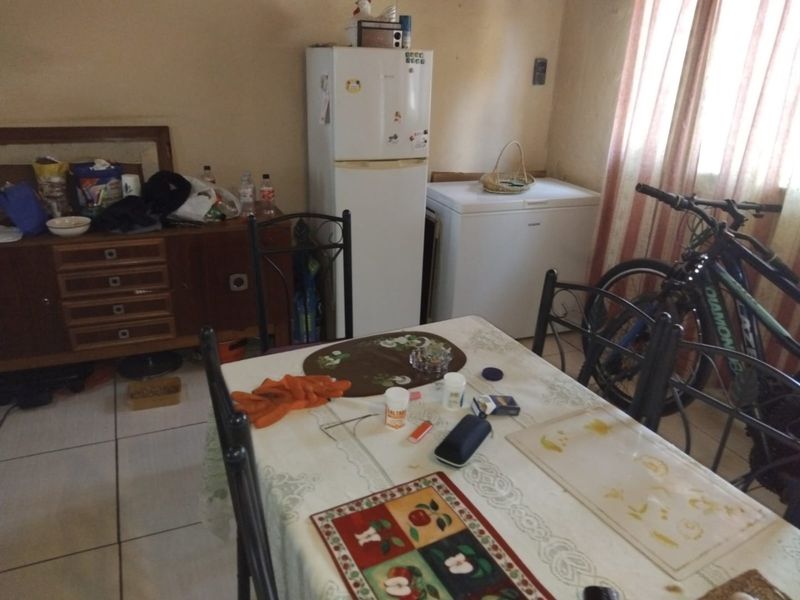 A dining area featuring tiled flooring and natural light from the window, offering a functional space for meals.