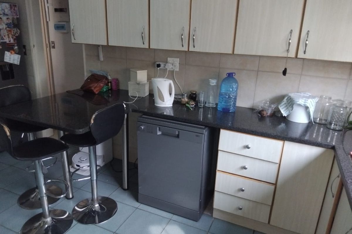 A functional kitchen featuring laminate cabinetry, granite countertops, tiled backsplash, and tiled flooring with an integrated dishwasher.