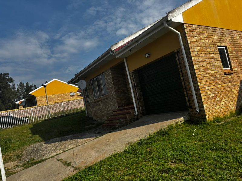 Front view of a face brick house featuring a single garage, concrete driveway, and established lawn area.