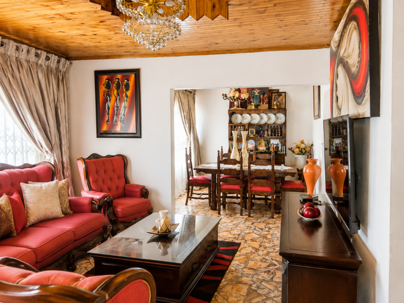Open plan living and dining area featuring a distinctive timber tongue and groove ceiling and stone-look tiled flooring throughout.