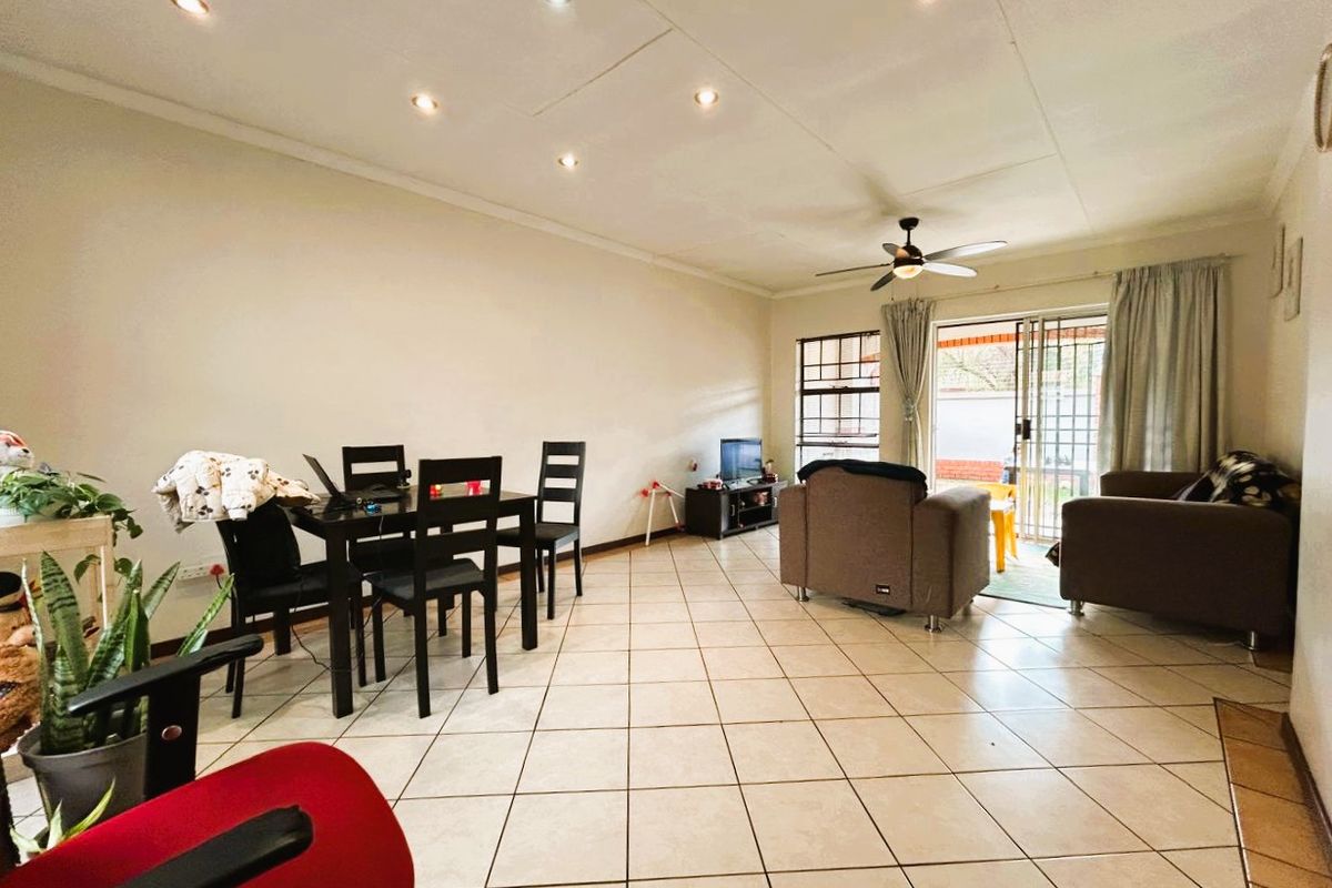 Spacious open-plan living and dining area featuring tiled flooring, recessed downlights, a ceiling fan, and direct access to the outdoor patio through sliding glass doors.