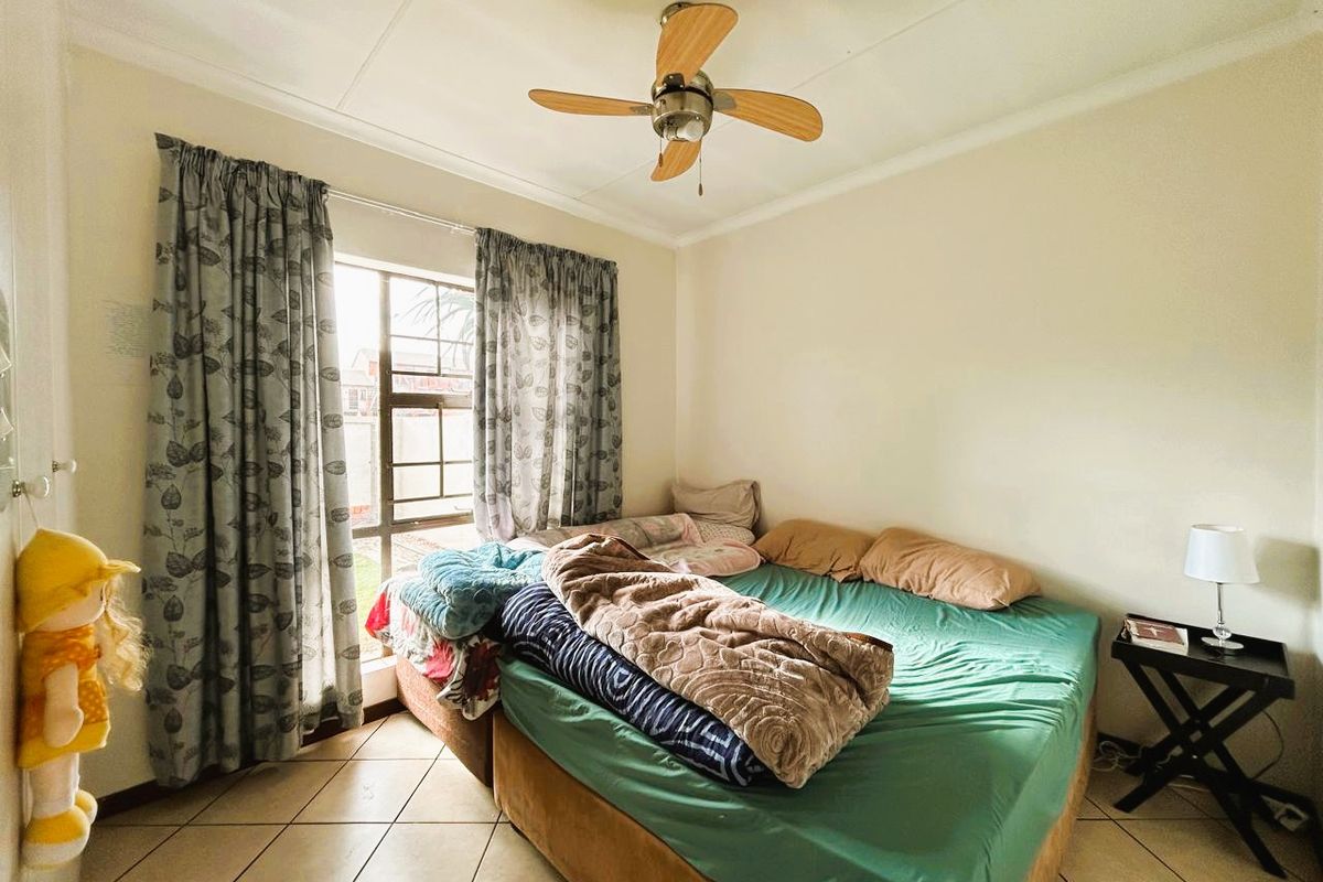 A functional bedroom featuring tiled flooring and a ceiling fan, offering a neutral space ready for personalization.
